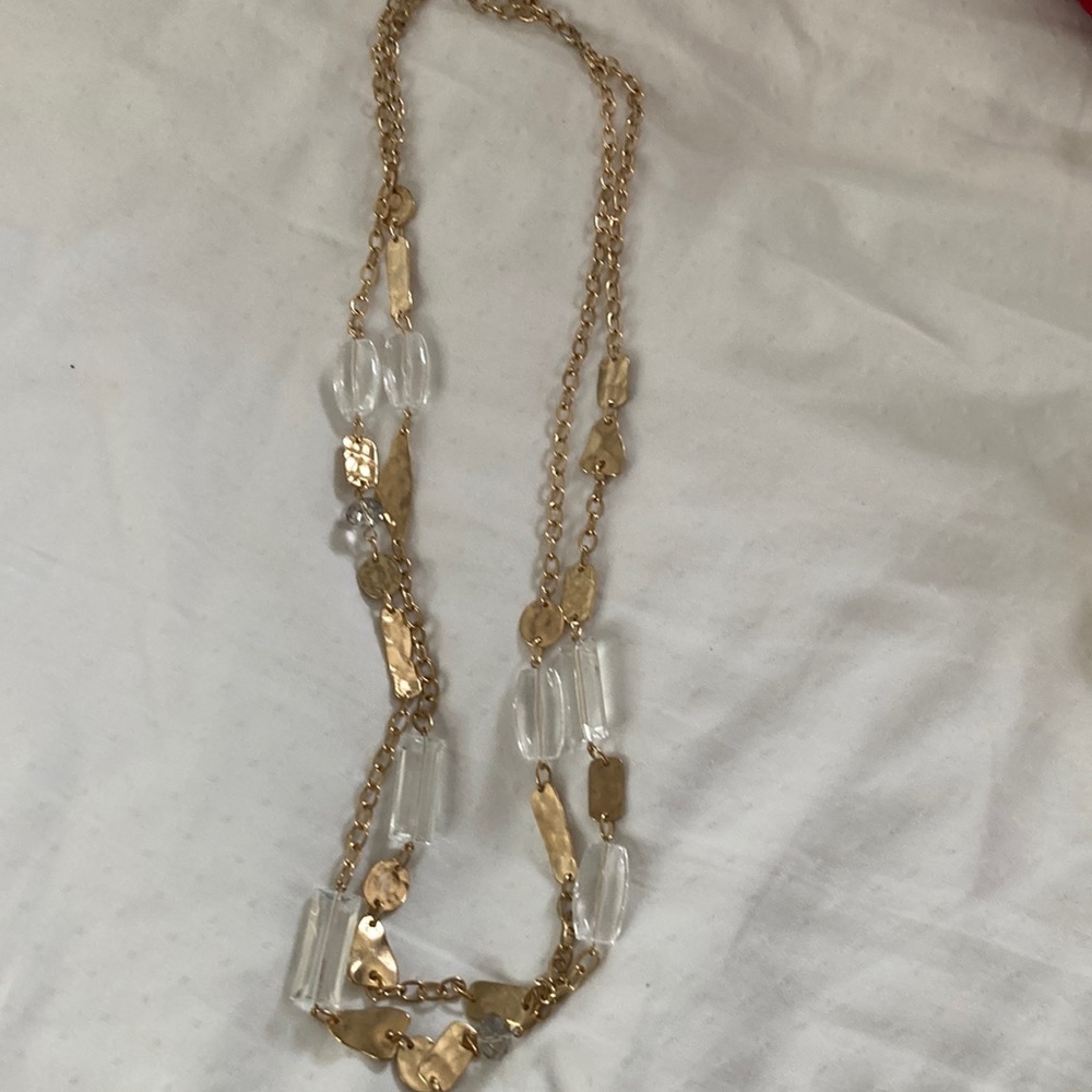 Necklace 36 inches long. Has gold like chain with white crystal like pieces.